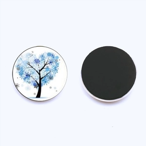 Detail of blue tree of life glass fridge magnet with snow heart and magnetic backing