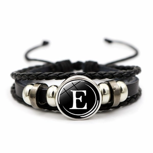 Detail of multilayer woven leather bracelet featuring a glass cabochon with letter E