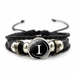 Close-up of multilayer leather bracelet with silver bead accents and letter I pendant