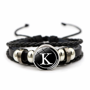 Detail of multi-layer woven leather bracelet featuring retro silver beads and letter K charm