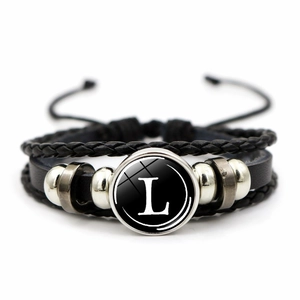 Detail of woven leather bracelet with letter L glass cabochon and metal beads