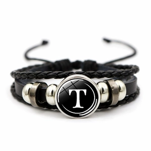 Detailed macro view of multilayer leather bracelet featuring letter T glass charm pendant