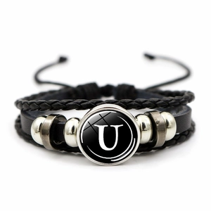 Detail of a braided leather multi-layer bracelet featuring a white letter U glass dome
