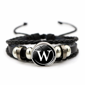 Detailed view of multilayer leather bracelet featuring letter W in a glass cabochon