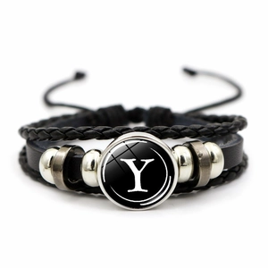 Detail of multi-layer woven leather bracelet featuring a silver letter Y glass pendant