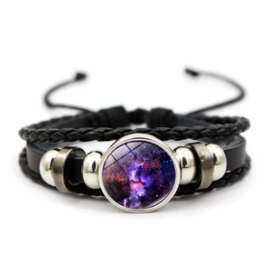 Detailed macro view of multi-layer braided leather bracelet with purple galaxy charm