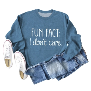 Detail of blue crewneck sweatshirt with white 'Fun Fact: I don't care' text print