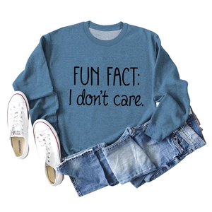 Flat lay of blue sweatshirt with 'FUN FACT: I don't care' text and casual denim styling