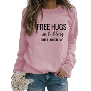 Detail of pink crewneck sweatshirt with FREE HUGS just kidding DON'T TOUCH ME slogan print