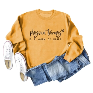 Flat lay of bright yellow physical therapy sweatshirt with heart logo and blue jeans