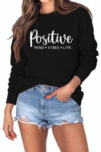 Gros plan du lettrage Positive Mind Vibes Life sur le sweat-shirt noir à manches longues