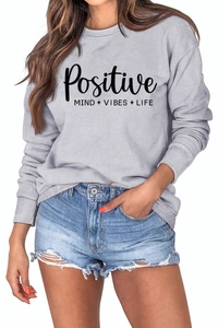 Détail des poignets côtelés et imprimé Positive Mind Vibes Life sur le sweat gris