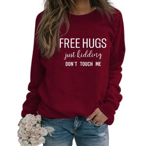 Detail of burgundy crewneck sweatshirt with Free Hugs slogan and denim jeans
