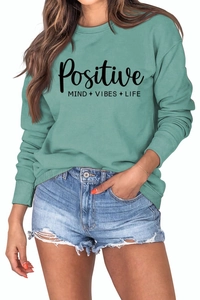 Détail du sweat-shirt vert sauge avec imprimé Positive Mind Vibes Life sur la poitrine