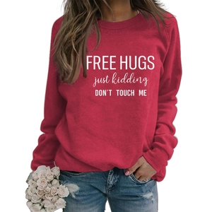 Detail of red crewneck sweatshirt featuring white Free Hugs Just Kidding printed text