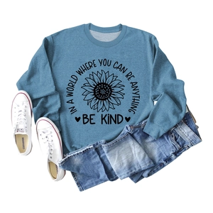 Detail of blue crewneck sweatshirt with sunflower print and Be Kind slogan