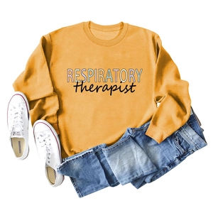 Detail of a mustard yellow sweatshirt with Respiratory Therapist colorful text and blue jeans
