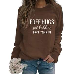 Detail of Free Hugs slogan print on dark brown crewneck sweatshirt with white lettering