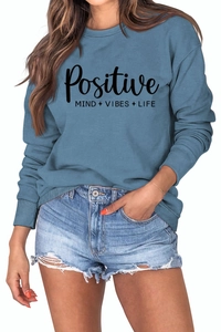 Détail d'un sweat bleu avec impression du slogan Positive Mind Vibes Life