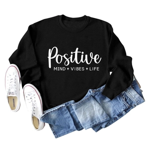 Mise à plat d'un sweat noir avec le texte Positive Mind Vibes Life et un jean bleu