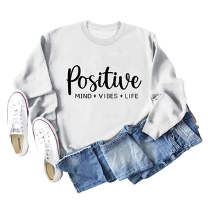Mise à plat d'un sweat blanc avec texte Positive Mind et un jean bleu clair