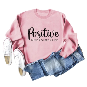 Vue à plat du sweat rose avec texte Positive Mind Vibes Life et jean en denim bleu