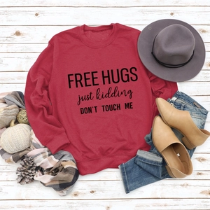 Red long sleeve sweatshirt featuring Free Hugs slogan with autumn flat lay styling