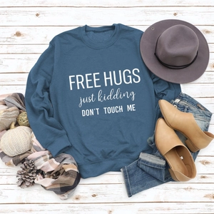 Flat lay of a blue long-sleeve sweatshirt with humor text and autumn accessories