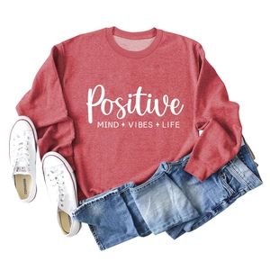 Vue à plat d'un sweat rouge à manches longues avec slogan Positive Mind Vibes Life et jean