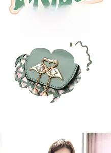 Detail of Morandi green saddle bag featuring golden swan buckle and pearl tassel
