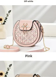 Detail of pink round crossbody bag with geometric cutout and golden swan pearl clasp