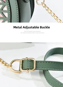 Detail view of bean green leather bag with hollow patterns and gold metal buckle
