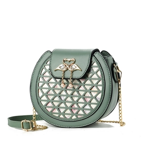 Sac bandoulière rond vert foncé avec motifs découpés au laser et fermoir cygne perlé