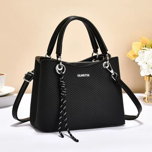 Elegant black textured handbag with dual handles and crossbody strap on a white surface