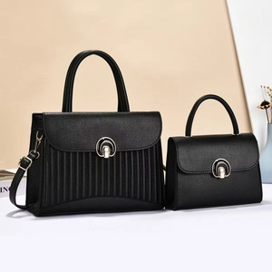 Close-up of black lychee grain leather handbag set with vertical pleated texture and metal buckle