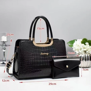 Close-up of black crocodile pattern tote bag with dimensions and gold logo detail