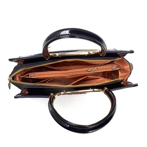 Internal view of black faux leather handbag with multi-layered compartments and brown lining