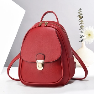 Close-up of red lychee leather mini backpack with golden metal rotary lock and zipper