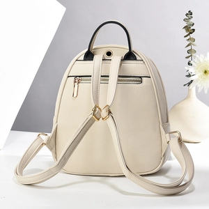 Macro detail of beige leather backpack showing adjustable straps and back zipper pocket