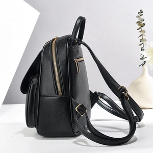 Detail of black lychee grain leather backpack with gold zippers and anti-theft back pocket