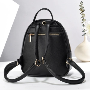 Detail view of black pebble leather mini backpack featuring a gold anti-theft zipper pocket