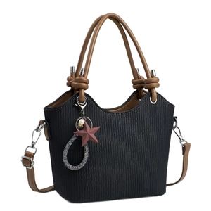 Minimalist black pleated tote bag with brown handles and a red star charm