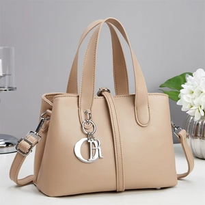 Elegant beige leather handbag with metal letter charms and detachable shoulder strap
