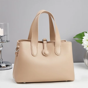 Detail of minimalist beige leather tote bag with smooth texture and double round handles