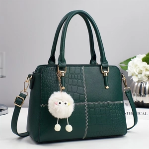 Elegante bolso de mano verde oscuro con relieves, costuras a contraste y un colgante