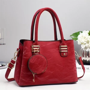 Détail du sac à main rouge en similicuir plissé avec des finitions dorées chic