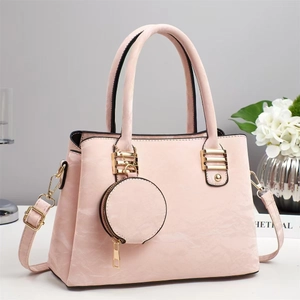 Gros plan du sac à main rose en similicuir avec détails dorés et porte-monnaie