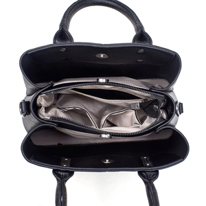 Top view of black leather handbag interior with herringbone lining and multiple compartments