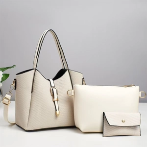 Detailed set of three creamy white handbags with woven texture and gold hardware details
