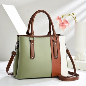 Modern patchwork tote bag with green and brown panels shown in a minimalist studio setting